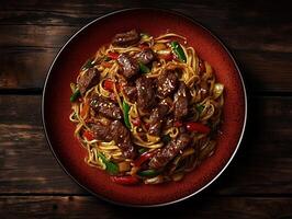 Delicious stir-fried noodles with beef and vegetables served in a rustic setting photo