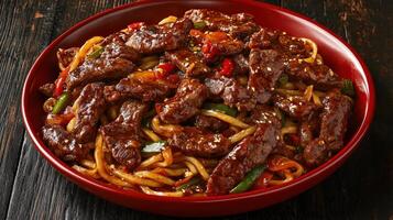 Chinese stir-fried beef with vegetables served in a red bowl photo