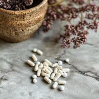 Natural supplements arranged on a textured surface with dried flowers photo