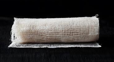 Rolled gauze bandage on a dark surface photo