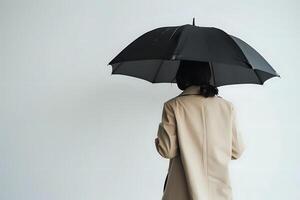 A Person in a Beige Coat Holds a Black Umbrella Under a Gray Sky, Walking Away Silently, a Reflective Moment of Solitude, Urban Exploration on a Cloudy Day, Finding Peace in Simplicity. photo