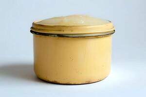 Exploring the Creamy Texture and Pale Yellow Hue of a Substance in a Vintage Container. A Detailed Visual Analysis of an Unidentified Compound's Physical Properties photo