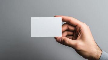 Hand Holding Blank White Card Against Grey Background photo