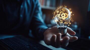 Hand Holding a Lightbulb with Glowing Gears Inside photo