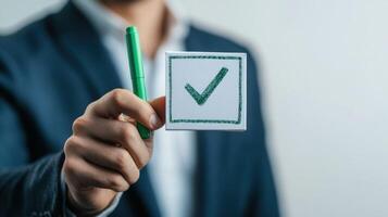 Person Holding a Check Mark on a White Card with a Green Marker photo