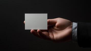 Hand Holding Blank White Card Against Black Background photo
