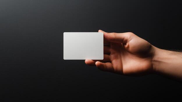 mano participación un blanco blanco tarjeta en contra un oscuro antecedentes foto