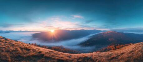 Golden Grass Hilltop Overlooking Misty Mountain Valley at Sunrise photo