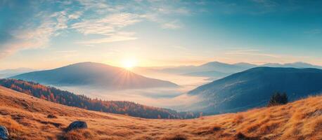 Mountainous Landscape with Fog, Golden Grass, and Sunrise photo