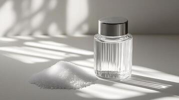 Traditional glass salt shaker displays white crystals through clear container. Metal cap with holes tops minimalist design, captured with soft window lighting and gentle shadows. shaker photo