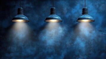 Soft light from three pendants illuminates a calming blue backdrop photo