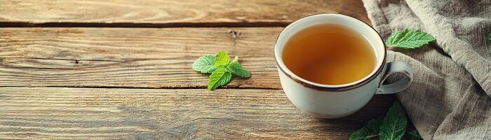 Inviting rustic table setting featuring a cup of herbal tea with fresh mint leaves in soft lighting photo