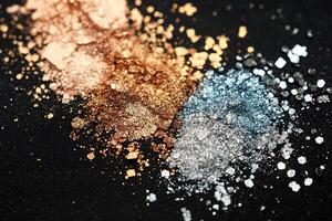 Luxurious abstract makeup texture showcases fine glitter powder in shimmering gold and silver tones against a matte black velvet background, offering bold elegance and ample space for text overlay photo
