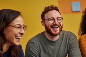 Three people laughing and smiling in front of a yellow wall photo
