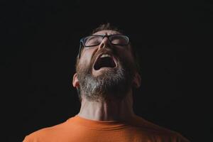A man with glasses and a beard is screaming photo