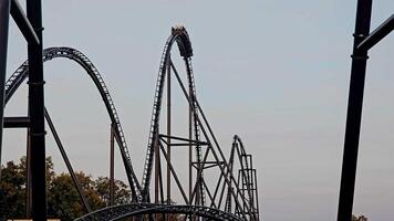 Large Steel Roller Coaster at Amusement Park, A massive steel roller coaster featuring multiple loops and drops at an amusement park video