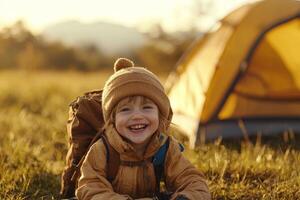 A joyful child enjoying outdoor adventure while camping near a bright yellow tent during sunset in a serene field photo