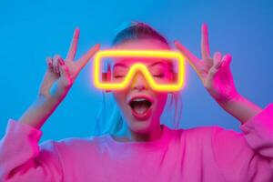 A young woman enjoys a vibrant party atmosphere wearing neon glasses and posing playfully against a colorful background photo