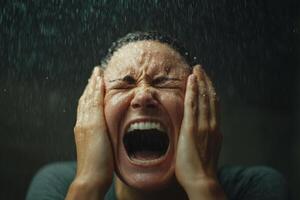 Dramatic close-up of a woman expressing intense emotions under running water in a dimly lit environment during an emotional moment photo