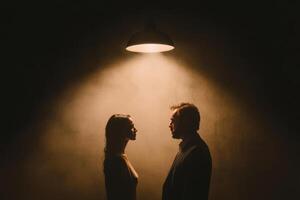 Intimate encounter between a couple under a spotlight in a dim room, evoking a sense of connection and emotion during a quiet moment photo