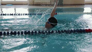 Swimmer splashing in pool lane, Swimmer creating splashes while practicing in a pool lane video