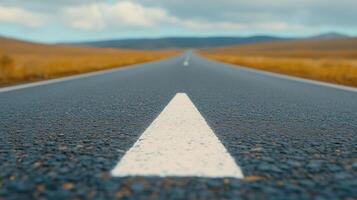 Endless Asphalt Road with Perspective View on a Clear Day Featuring White Stripe and Scenic Horizon under a Vast Blue Sky photo