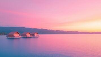 Tranquil Overwater Bungalows at Dusk with Vibrant Sunset Sky Reflecting on Calm Ocean Waters Under Pastel Sky photo