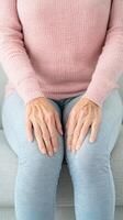 Senior Woman Massaging Knee Pain While Sitting on Sofa with Arthritis Symptoms at Home for Therapeutic Relief and Relaxation photo