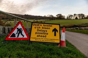 Road works sign announces possible delays in welsh and english languages photo