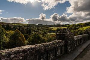 Sun shining over llyn vyrnwy dam and stone bridge in powys, wales photo