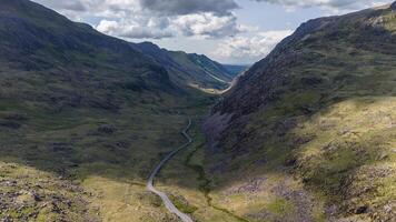 Serpentine mountain road in lush valley photo