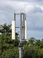 Telecommunication tower providing wireless communication under cloudy sky photo