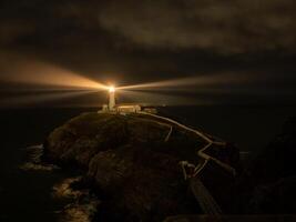 South Stack Lighthouse illuminating the darkness of the night photo