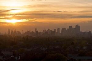 Canary Wharf business district at sunset, seen from a residential area in London, United Kingdom photo