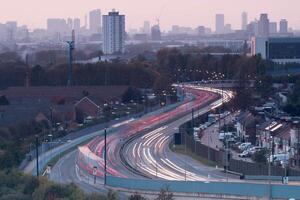 Highway traffic light trails illuminating London skyline at dusk photo
