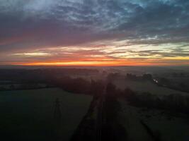 Plymouth Red and orange sunrise illuminating foggy fields and railway near Plymouth, Devon, England photo