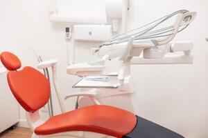 Modern red dentist chair stands in empty office photo