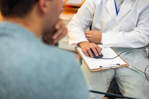 Dentist showing information to patient using computer mouse and clipboard photo