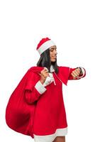 vertical Girl dressed as Santa Claus checking the time on her wristwatch while holding sack of gifts photo
