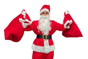 Santa Claus holding two sacks of gifts high while looking at the camera white background photo