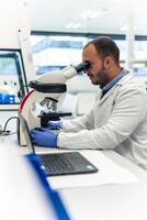 Scientist using microscope in laboratory doing bio scientific research photo