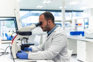 Scientist using microscope in modern laboratory performing research photo