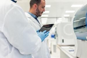 Scientists using tablet and working in modern laboratory photo