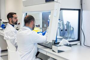 two Scientists working with advanced equipment in modern bio laboratory photo