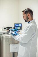 Scientist taking notes on a clipboard in laboratory photo