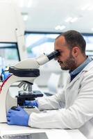 Scientist adjusting microscope, conducting research in laboratory photo