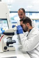 Scientists working with microscope in laboratory doing research photo