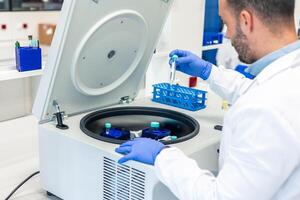 Lab technician preparing samples for analysis using laboratory centrifuge photo