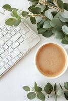 Calm workspace with coffee cup and eucalyptus leaves on a clean desk setting photo