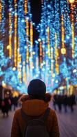 Young man gazing at a bright cityscape at night surrounded by glowing lights photo